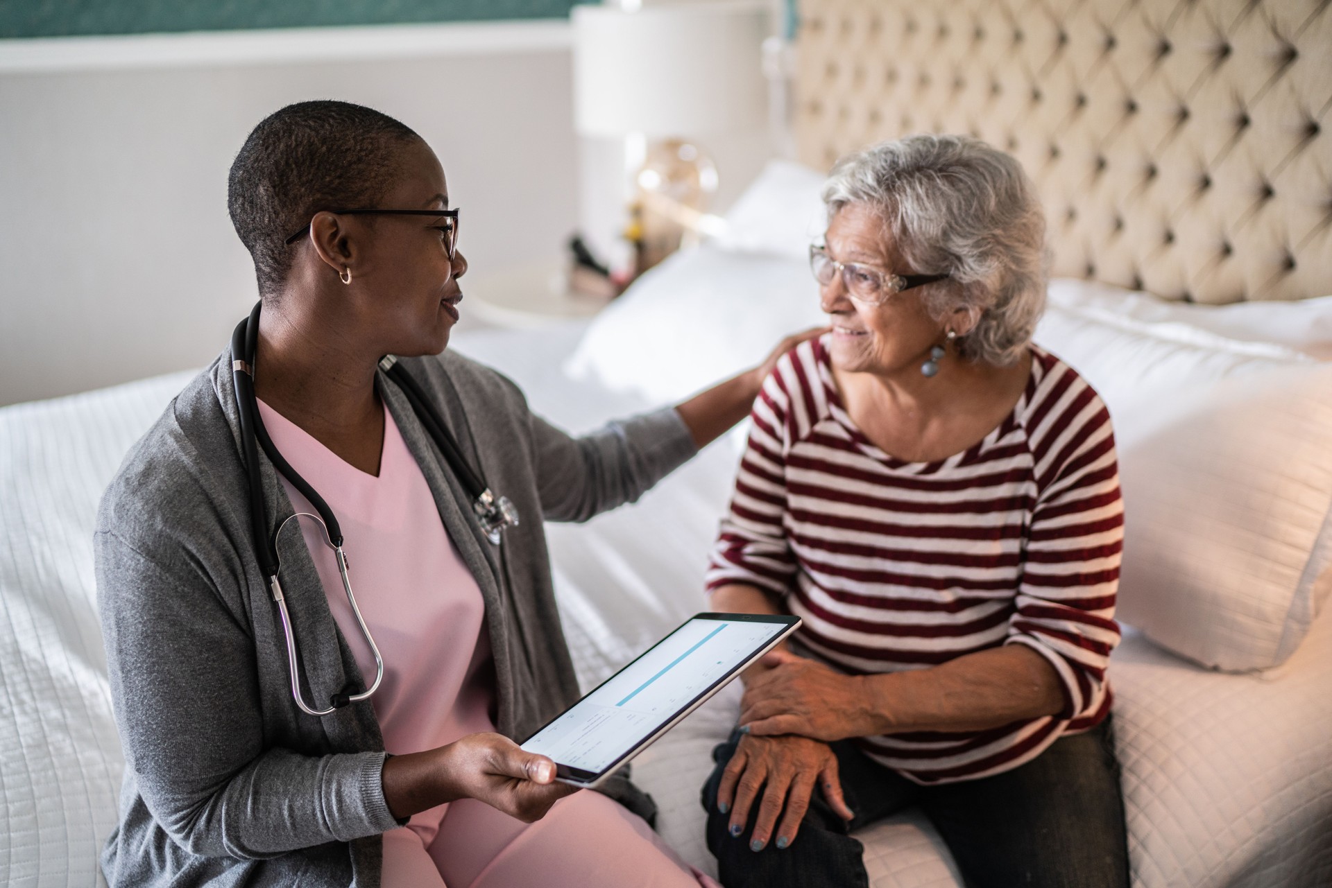 Doctor talking to a senior woman in the bedroom