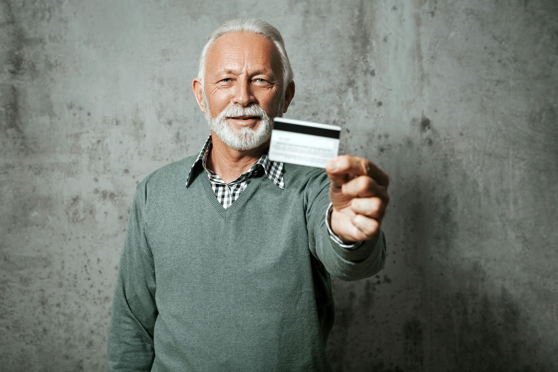 Smiling senior businessman holding credit card